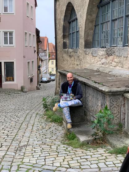 Picture of me on my laptop in the middle of a medieval town
