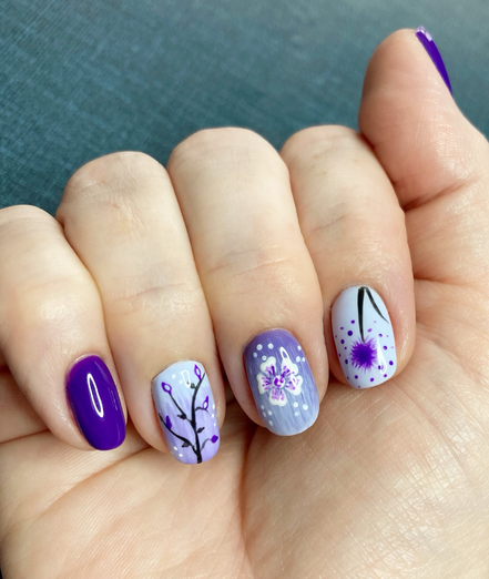 Nails with hand painted flowers in shades of lilac and purple