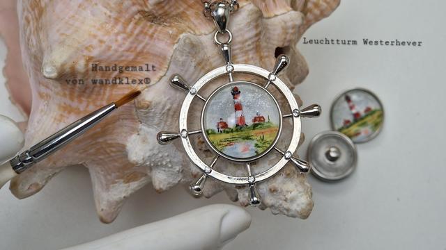 Anhänger in Form eines Schiffsruders mit eingesetztem handgemaltem Druckknopfmotiv (wechselbar) mit einer winzigen Darstellung des Leuchtturms Westerhever.