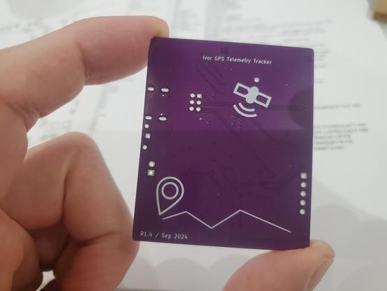 The back of a purple circuit board with a GPS tracking pictograph.