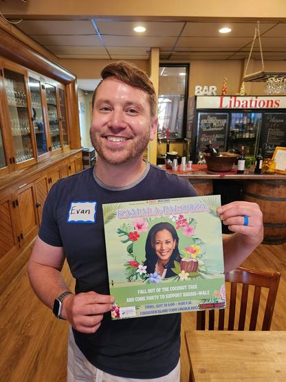 Evan smiling and holding a poster