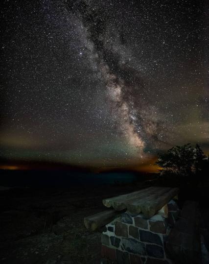 A. New of the Milky Way over Lake Superior. A picnic table is in the foreground.