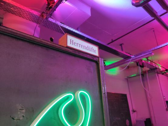 A wooden box with an acrylic wall reading "Herrendüfte" on it. The acrylic wall is illuminated from behind.