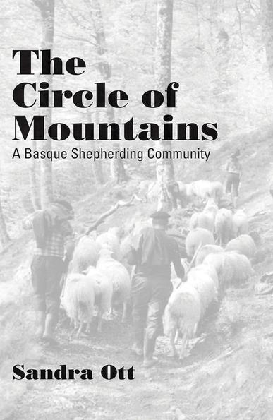 Portada del llibre, amb el títol "The Circle of Mountains. A Basque Shepherding Community". De fons, uns pastors porten unes ovelles per un bosc amb pendent