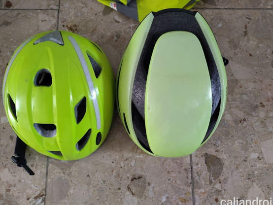 Zwei neongelbe Radhelme auf einem Steinfliesenboden. 
Der Linke von Abus ist älter, dennoch ist die Farbe noch leuchtkräftig wie am Anfang, also UV stabil.

Rechts der Lumos Ultra Helm. Die Farbe ist stark verblasst.