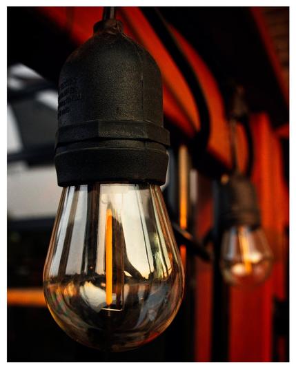 Close up of a pair of light bulbs reflecting the setting sun.