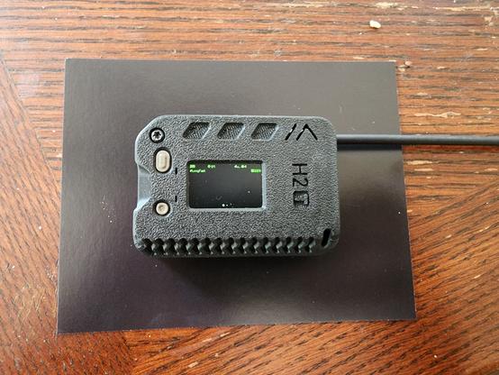 muzi.works H2T portable meshtastic client node, black, with a small antenna coming out on the right side