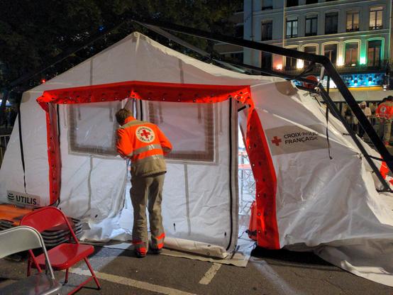 Tente de secours de la Croix-Rouge française, un secouriste en tenu s'apprête à y pénétrer.