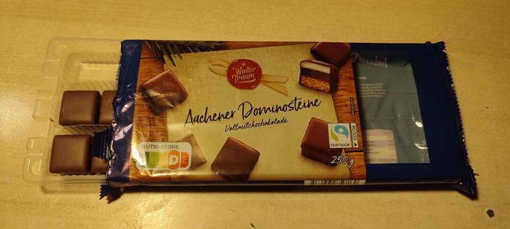 Bild einer angebrochenen packung aachener dominosteine weihnachtssüßigkeit in vollmilchschokolade.