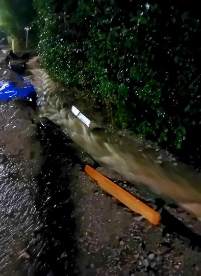 Komplett überfüllter Straßengraben, der mit provisorischen Dämmen befestigt ist.