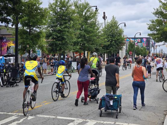 People walk and bike on a street closed to cars
