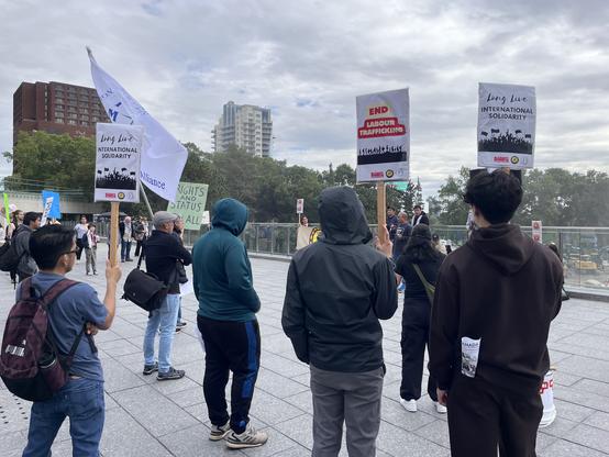 People holding signs at a migrant rights rally.
