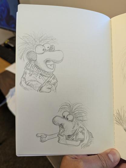 sketchbook page of two drawings of wembly, one in a winter sweater and earmuffs, the other viewed from the side with his mouth open pointing.