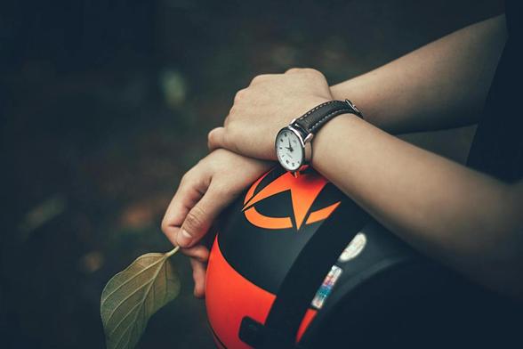 person holding black and orange helmet