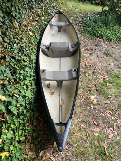 A plastic canoe with what appears to be a metal support rod that goes from the front to the back