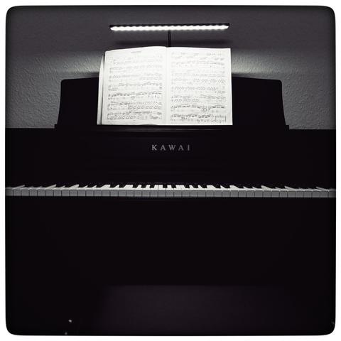 Black and white photograph of a Kawai e-piano in the dark.
