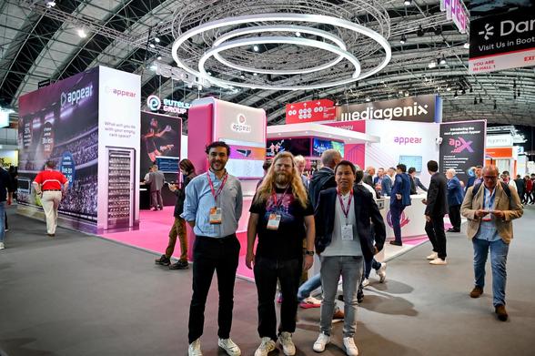 Francisco, Anders and Dexter, employees at Appear, standing in front of the Appear stand at IBC2024.