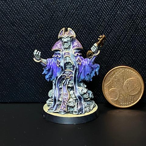 A skeleton in purple and silver robes with gold trim. It's on a pile of bones (mostly skulls) and is holding a big key.