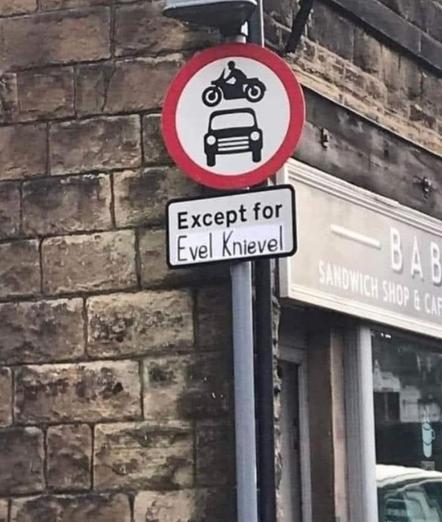 Photo of some traffic signs on pole in an intersection, right next to the corner of a brick building. The top sign is round, with a red thick line around the edge. Inside that, are two symbol icons: a motorcycle which is seemingly floating over a car symbol.

Below the circular sign is a rectangular sign. This lower sign has been altered by someone with a marker and paper to say, “Except for Evel Knievel.”
