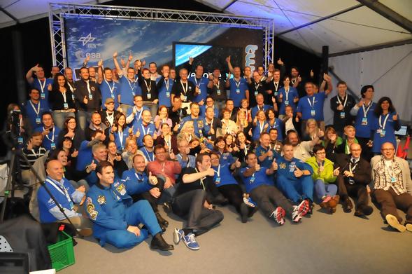 Environ 80 personnes réunies pour une photo de groupe, de nombreux astronautes se sont mélangés aux participants.
