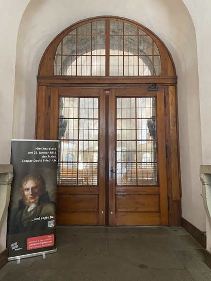 Plakat mit dem Porträt des Malers an der Inneren Tür der Kreuzkirche weist auf die Heirat hin.