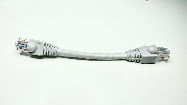 A category 6 8-wire Ethernet patch lead, with grey insulation and boots, with the usual clear acrylic crimped plugs on each end. The plugs and boots make up half its overall length.