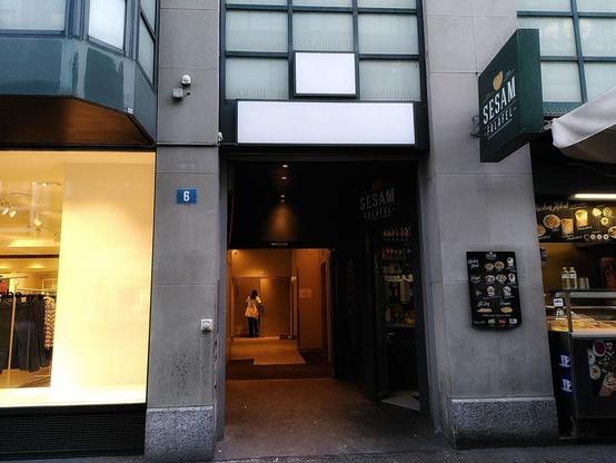 An entrance to an office building, with a Falafel stand next to it