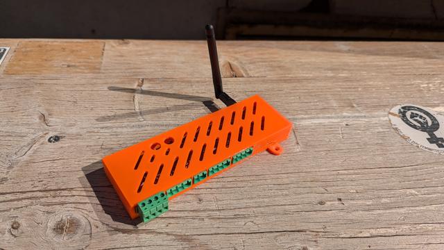 Photo of self-designed 3D printed enclosure with PCB inside and antenna on the side.