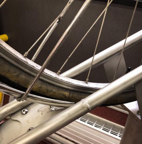 Close-up of a bicycle fender getting squished between a tire and the rack.