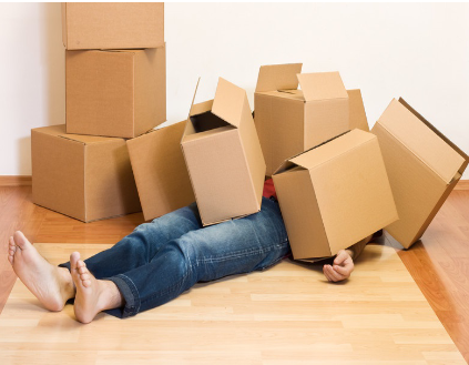 Une personne est ensevelie sous des cartons de déménagement.