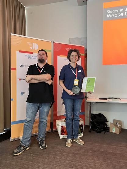 Sigrid Gramlinger (r) Harald Leithner (l) on stage holding the motto prize