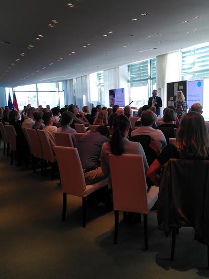 Well attended meeting, showing attendees in meeting room from the back