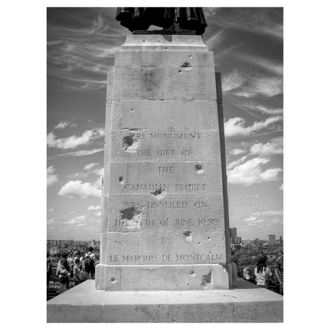 Black and white shot of the plinth holding the statue of General Wolfe in Greenwich Park. There is visible damage on the plinth from bomb or strafe damage in WWII