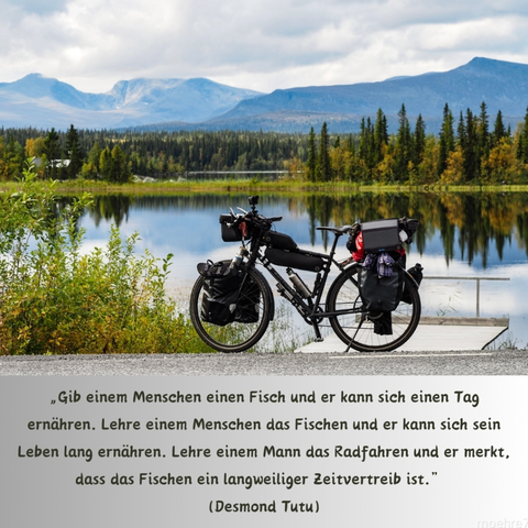Bild von einem vollgepackten Reiserad vor einem See, in dem sich die Berge im Hintergrund spiegeln.
darunter der Ausspruch von Desmond Tutu:
Gib einem Menschen einen Fisch und er kann sich einen Tag ernähren. Lehre einem Menschen das Fischen und er kann sich sein Leben lang ernähren. Lehre einem Mann das Radfahren und er merkt, dass Fischen ein langweiliger Zeitvertreib ist.