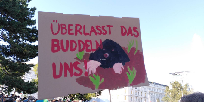 Demoplakat mit einem aufgemalten Maulwurf. Daneben der Text "Überlasst das Buddeln uns!"