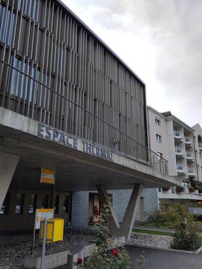 Foto. Eine Bushaltestelle direkt an einem Gebäude.