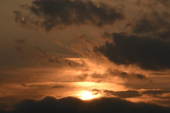 El Sol poniendose por primera vez en Otoño. Un cielo entre oscuro y anaranjado con unas cuantas nubes que tapan el Sol