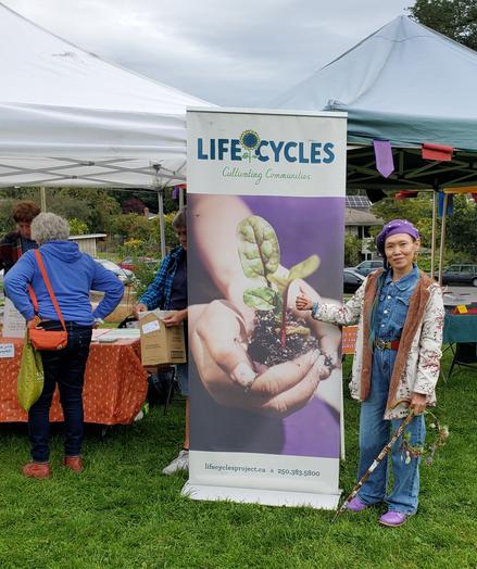 Me, in front of our LifeCycles Project booth & sign banner