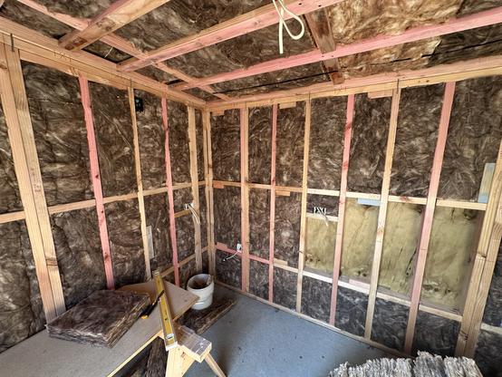 Installing insulation in the ceiling and walls of the office/maker space