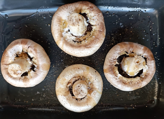 vier Riesenchampignons in einer Auflaufform vor dem Backen