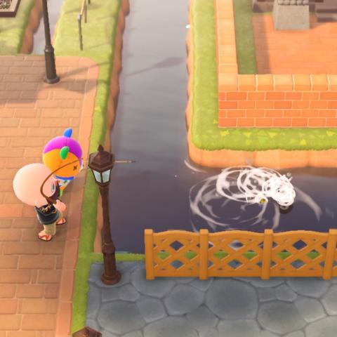 Animal Crossing: New Horizons screenshot. Photo shows Stitches (patchwork bear cub) and a human islander (bald, bearded, blue eyes) shown from the side standing on the town square fishing into a small river that runs alongside it. There is a concrete walkway immediately south of the river. The human is catching a fish and the water is splashing wildly.