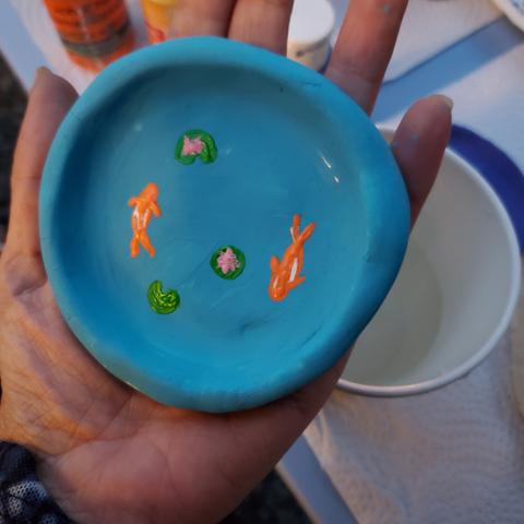 Painted blue clay dish with 2 orange koi fish, lotus flowers & lilypad.