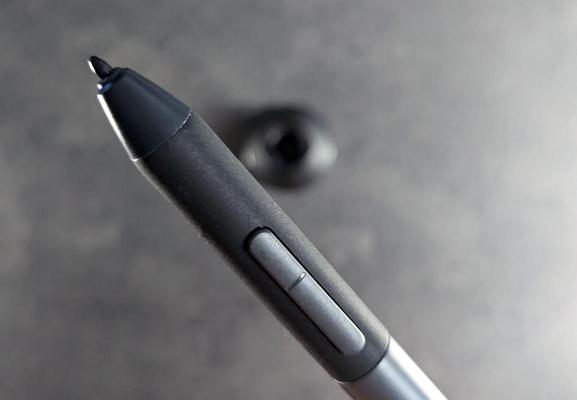 A close up photo of a digital stylus showing the pen nib and two shortcut buttons.