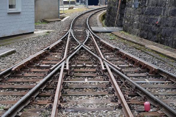 Three railway tracks joining into one via a rail switch
