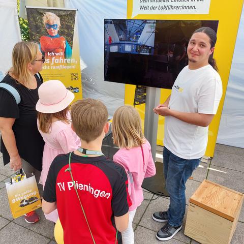 Am bwegt-Stand auf dem Schlossplatz Stuttgart versuchen sich Kinder am Zugsimulator.