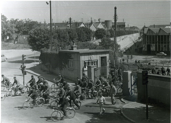 Photo noir et blanc, des années 1950. On y voit une marée de vélos et quelques piétons sortir des usines du Creusot.

Sortie d’usine au Creusot dans les années 50. Collection Académie François Bourdon – Le Creusot