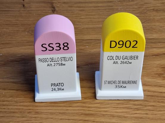 Kleine Replika von Straßenmeilensteinen. Einer vom Stilfser Joch, einer vom Col du Galibier.