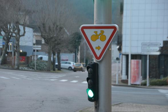 Pannonceau Cédez-le-passage cycliste accroché à un feu tricolore.