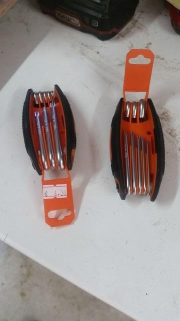 Due set di giraviti Torx tipo coltellino svizzero, in plastica arancione con fianchi neri gommosi.
