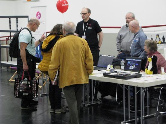 Foto: Unser Stand im Jahr 2023. Einige interessierte Personen lassen sich über Linux und Freier Software informieren.